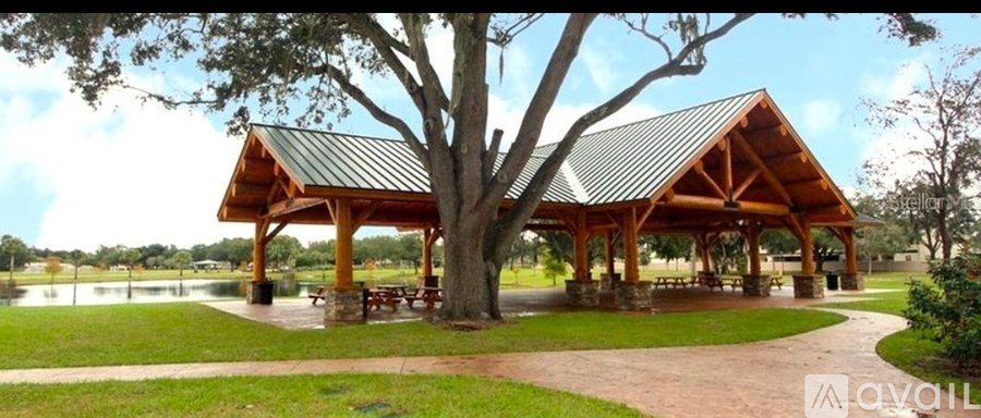 A pavilion with a large tree in front of it.