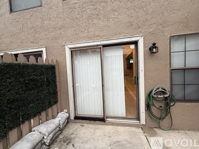 A house with a glass door and a hose on the ground.