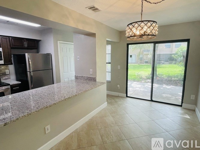 A kitchen with granite countertops and a refrigerator.