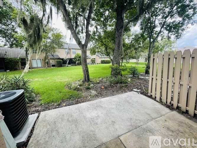A backyard with a fence and a tree.