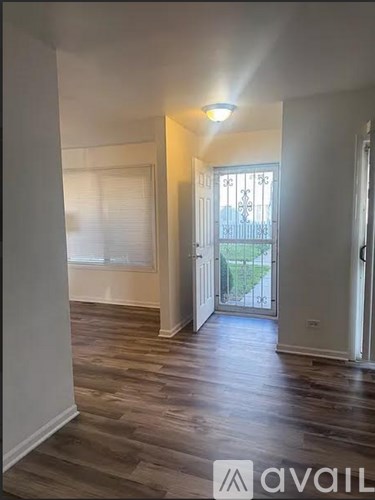 A room with wooden floors and a door leading outside.