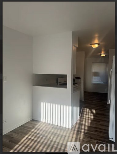 A room with wooden flooring and white walls.