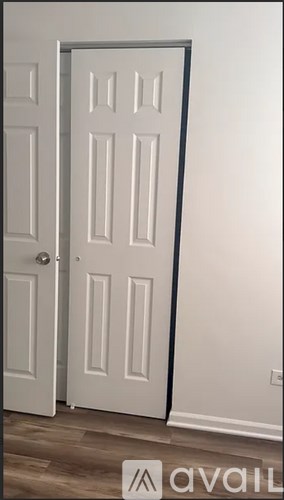 A white door with a black frame is open.