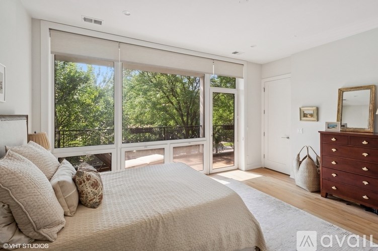 A bedroom with a large bed and a dresser with a mirror.