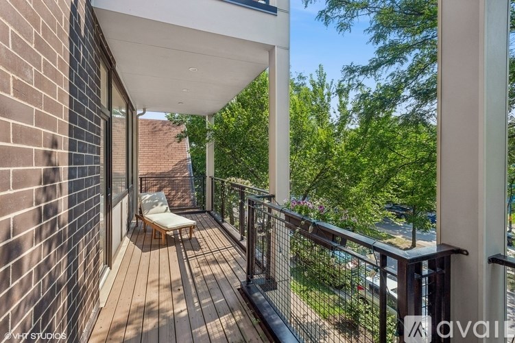 A balcony with a chair and a railing.