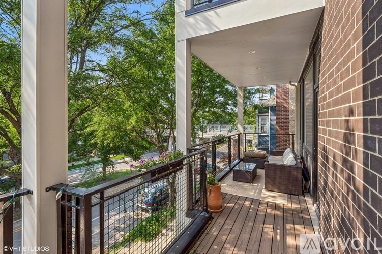 A balcony with a table and chairs overlooking a street.