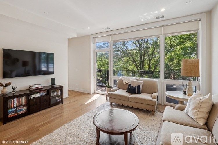 A living room with a flat screen TV, a couch, a coffee table, and a large window.