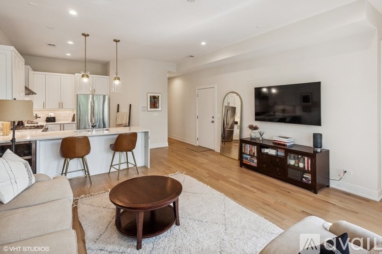 A modern living room with a wooden coffee table and a large flat screen TV.
