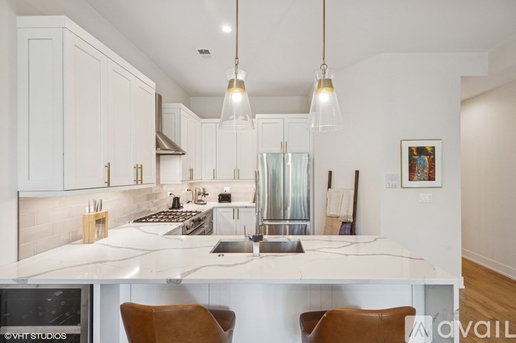 A modern kitchen with white cabinets and a marble countertop.