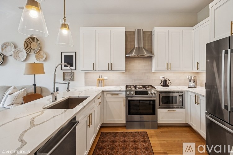 A modern kitchen with white cabinets and stainless steel appliances.