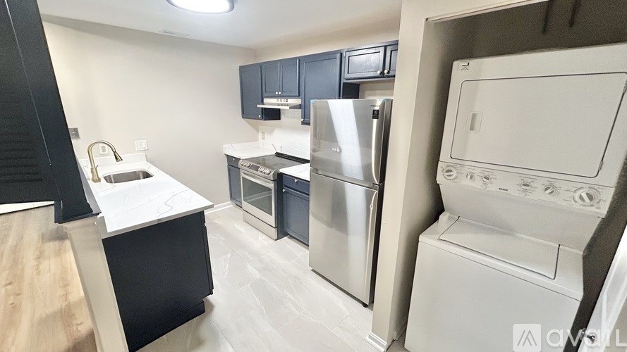 A kitchen with a refrigerator, oven, and microwave.
