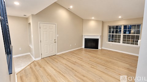 A room with wooden flooring and a fireplace.