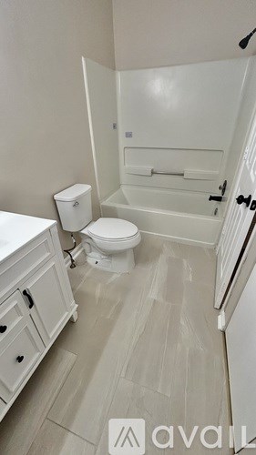 A white toilet in a bathroom with a white towel rack.