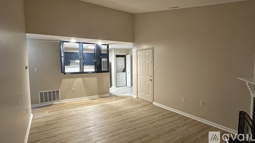 A room with a wooden floor and a white door.