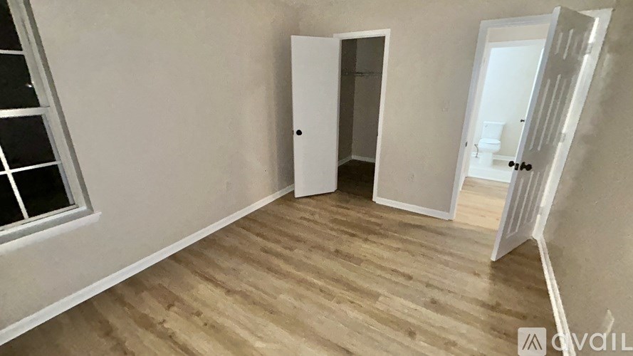 A room with a wooden floor and a white door.