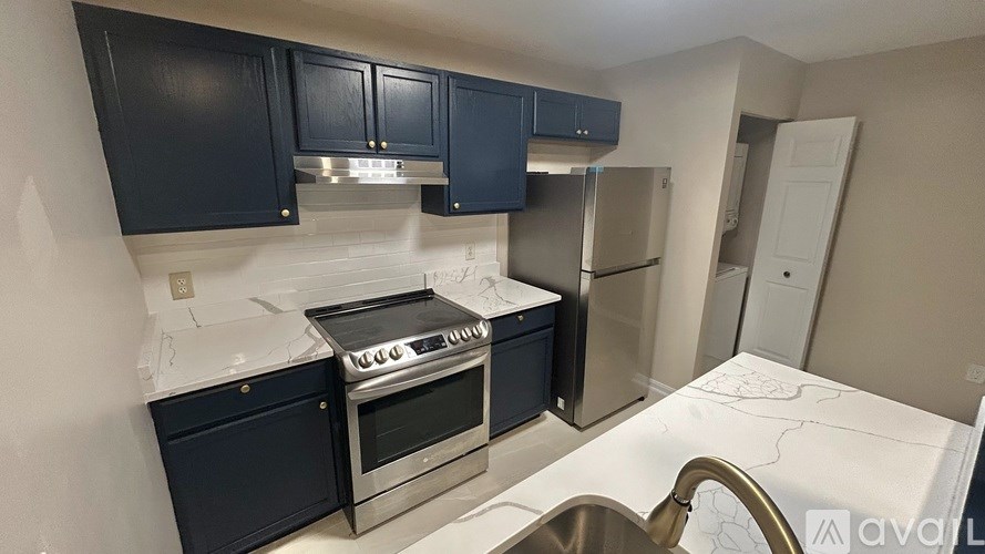 A kitchen with dark blue cabinets and stainless steel appliances.