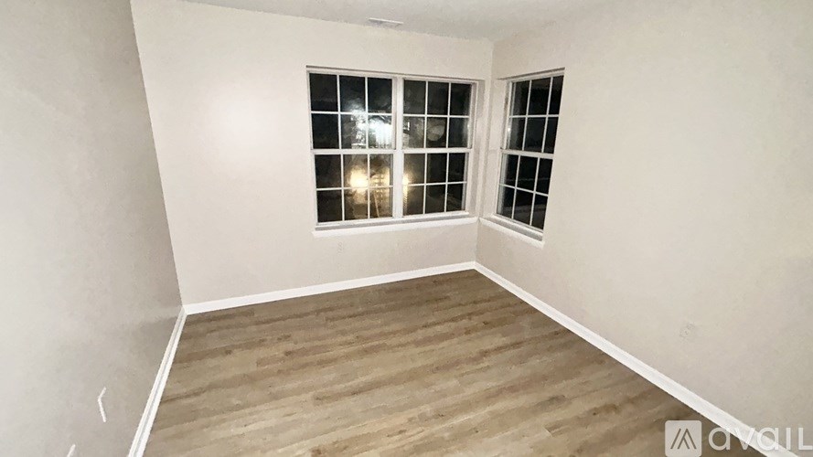 A room with a window and wooden flooring.