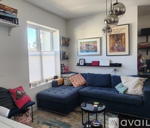 A living room with a blue couch and a small table.