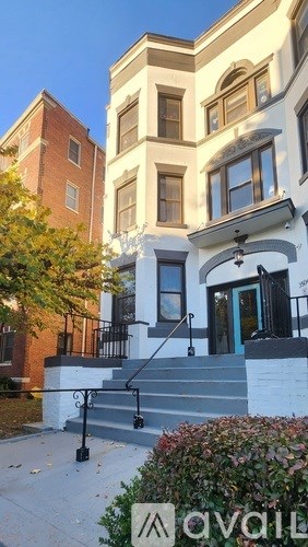 A house with a black gate and steps leading to the front door.