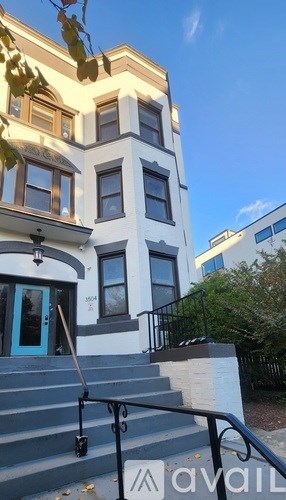 A building with a blue door and a sign that says "available" in front of it.