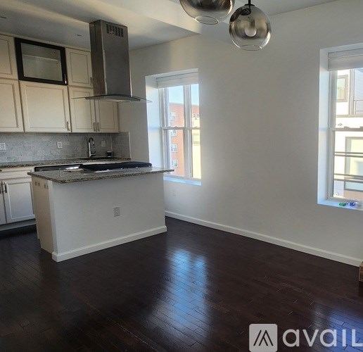 A kitchen with white cabinets and a marble countertop.