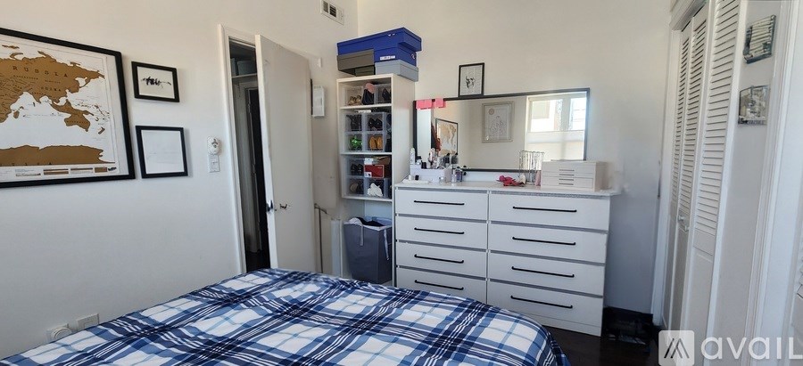 A bedroom with a bed, dresser, and mirror.