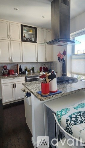 A kitchen with white cabinets and a white dishwasher.