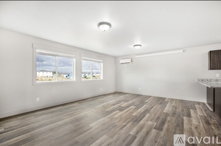 A room with wooden flooring and a large window.