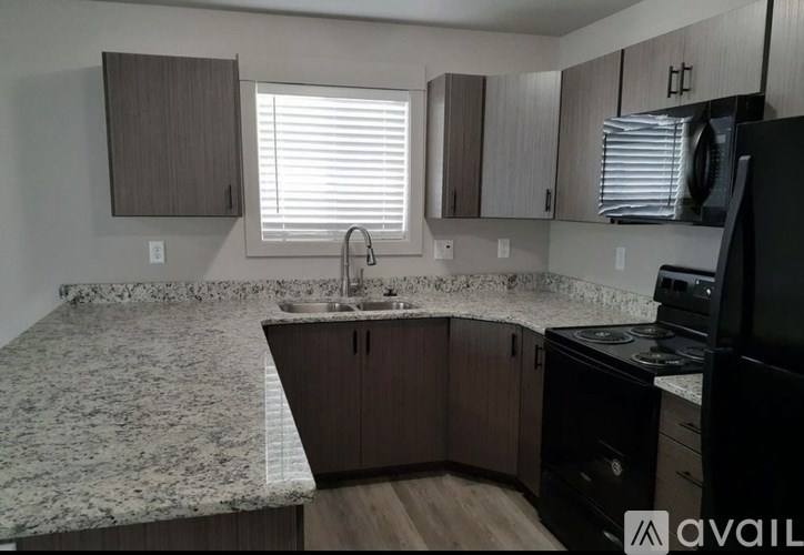 A kitchen with granite countertops and wooden cabinets.