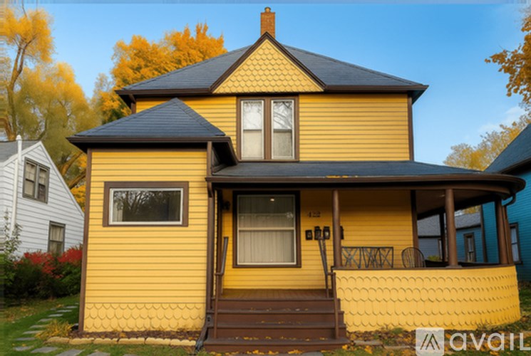 A yellow house with a black roof and a brown door.
