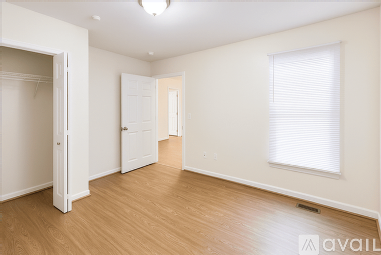 A spacious room with wooden floors and white walls.