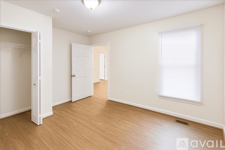 A spacious room with wooden floors and white walls.