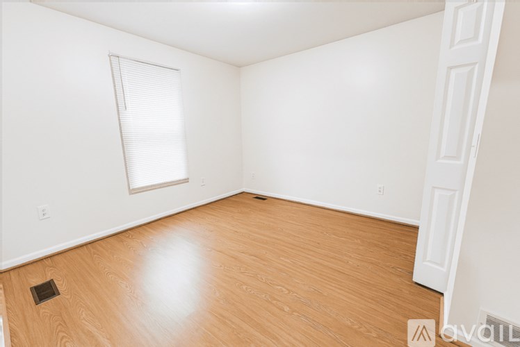 Empty room with wooden floor and white walls.