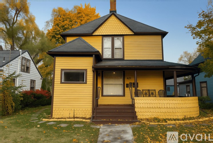 A yellow house with a black roof and a brown door.