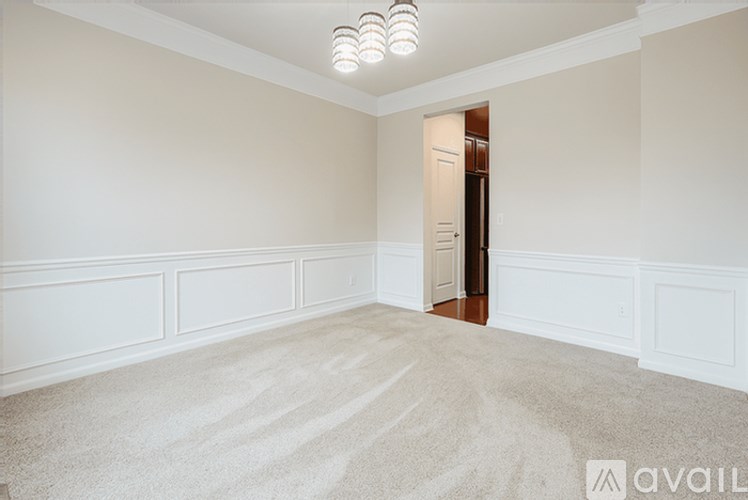 A room with a carpeted floor and a door on the right side.