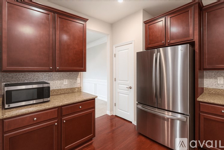 A kitchen with brown cabinets and a stainless steel refrigerator.