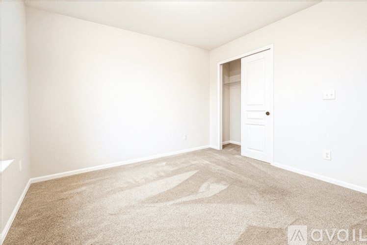 A room with a carpeted floor and a door leading to another room.