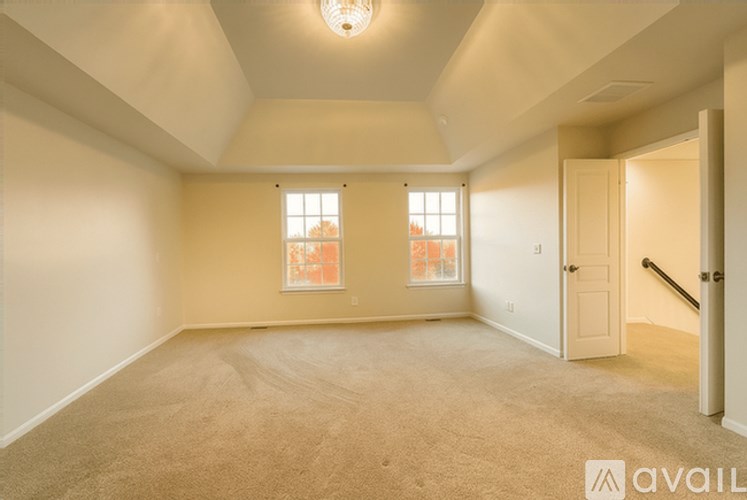 A room with a carpeted floor and a window with a view of a city skyline.