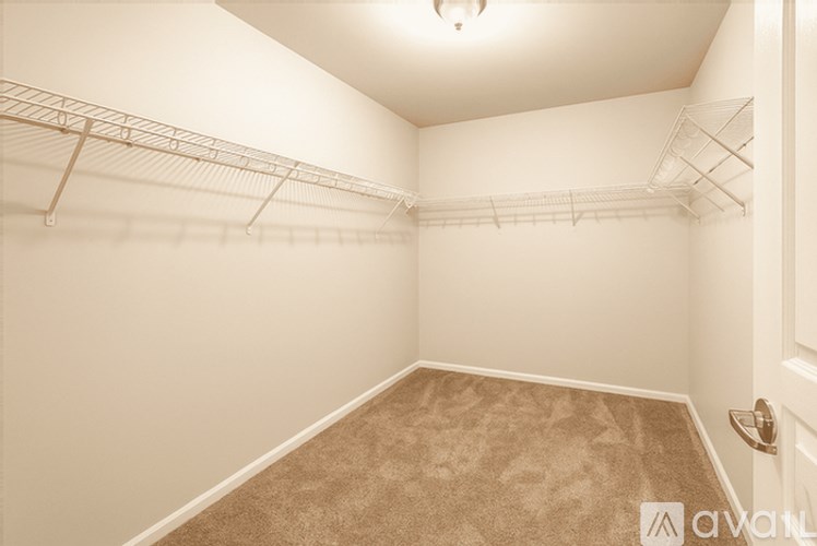 A room with a carpeted floor and a door on the right side.