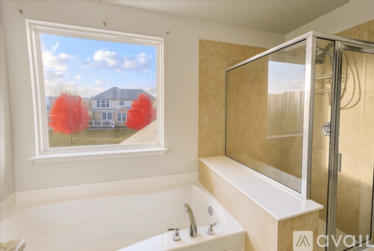 A bathroom with a large tub and a window showing a house and trees.