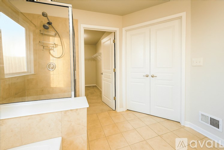A bathroom with a walk-in shower and a white door.