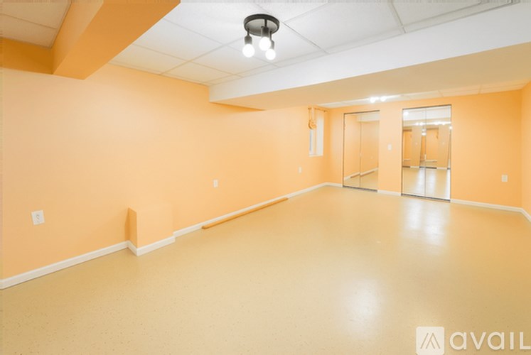 A spacious room with orange walls and a white ceiling.