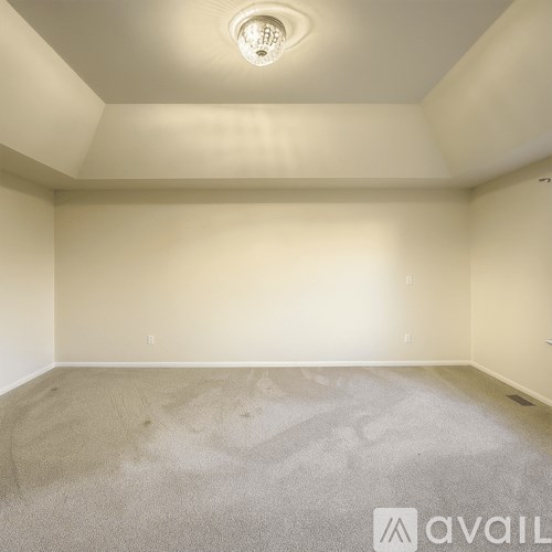 A room with a carpeted floor and a ceiling light.