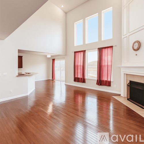 A spacious living room with a fireplace and large windows.