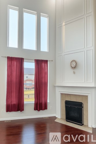 A living room with a fireplace and a clock on the wall.