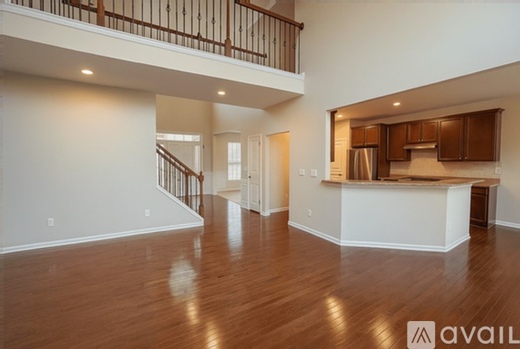 A spacious living room with a kitchen area in the background.