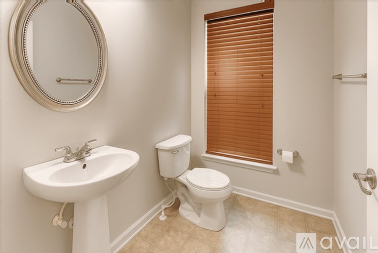 A bathroom with a toilet, sink, and mirror.
