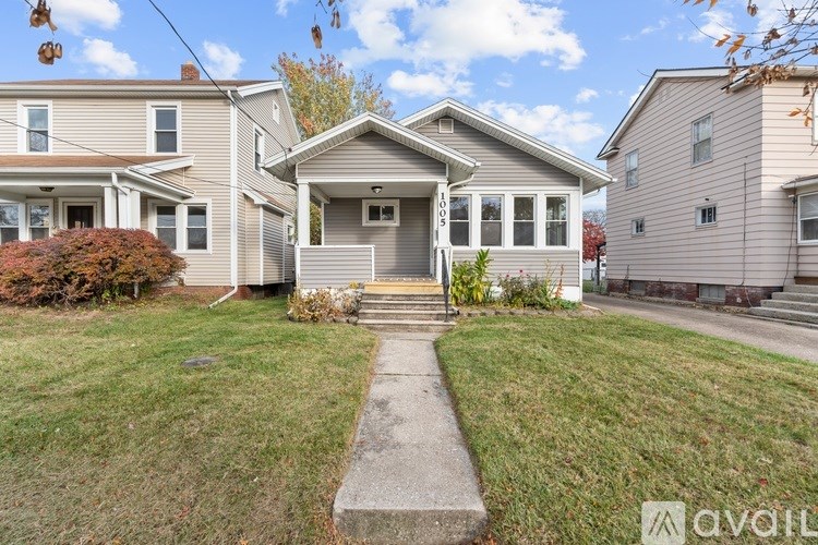 A house with a front yard and a sidewalk in front of it.