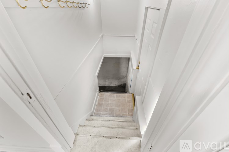 A stairway with a tiled floor leads to a door.