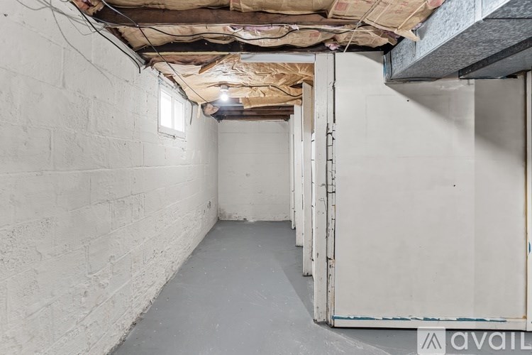 A long, narrow hallway with a door on the right and a wall on the left.